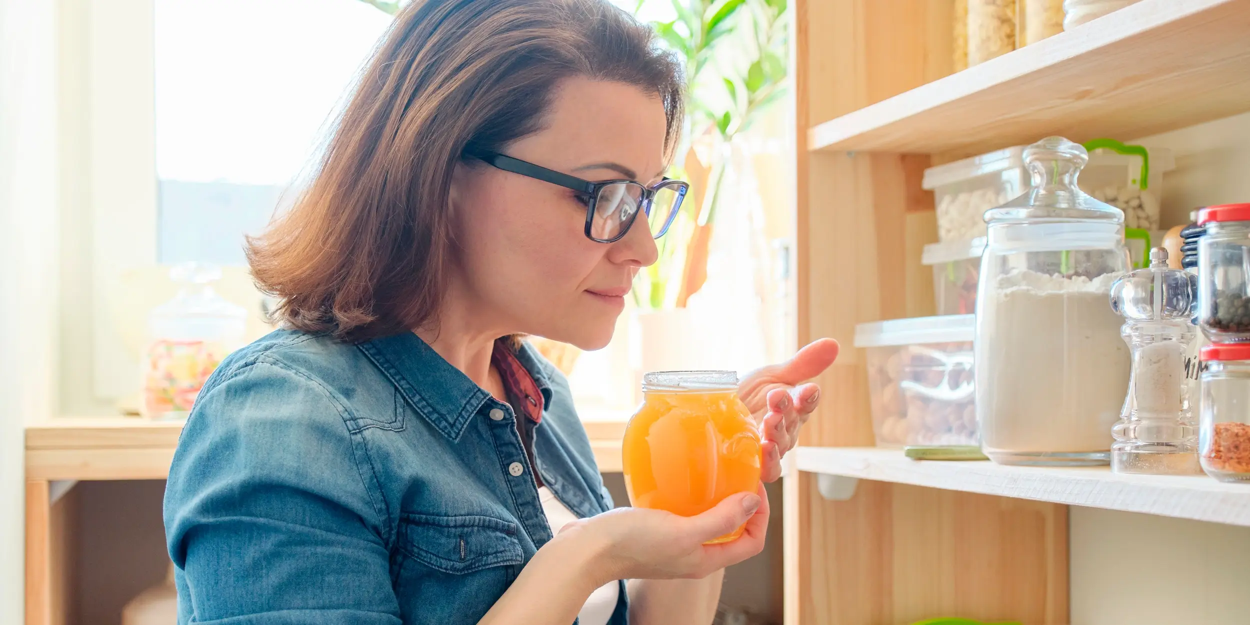 Filling a jar with fresh, golden honey.